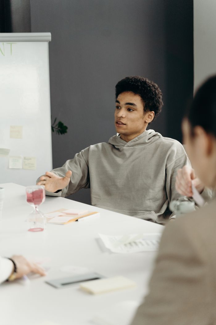 A young professional engaged in brainstorming session during a meeting in a modern office setting.
